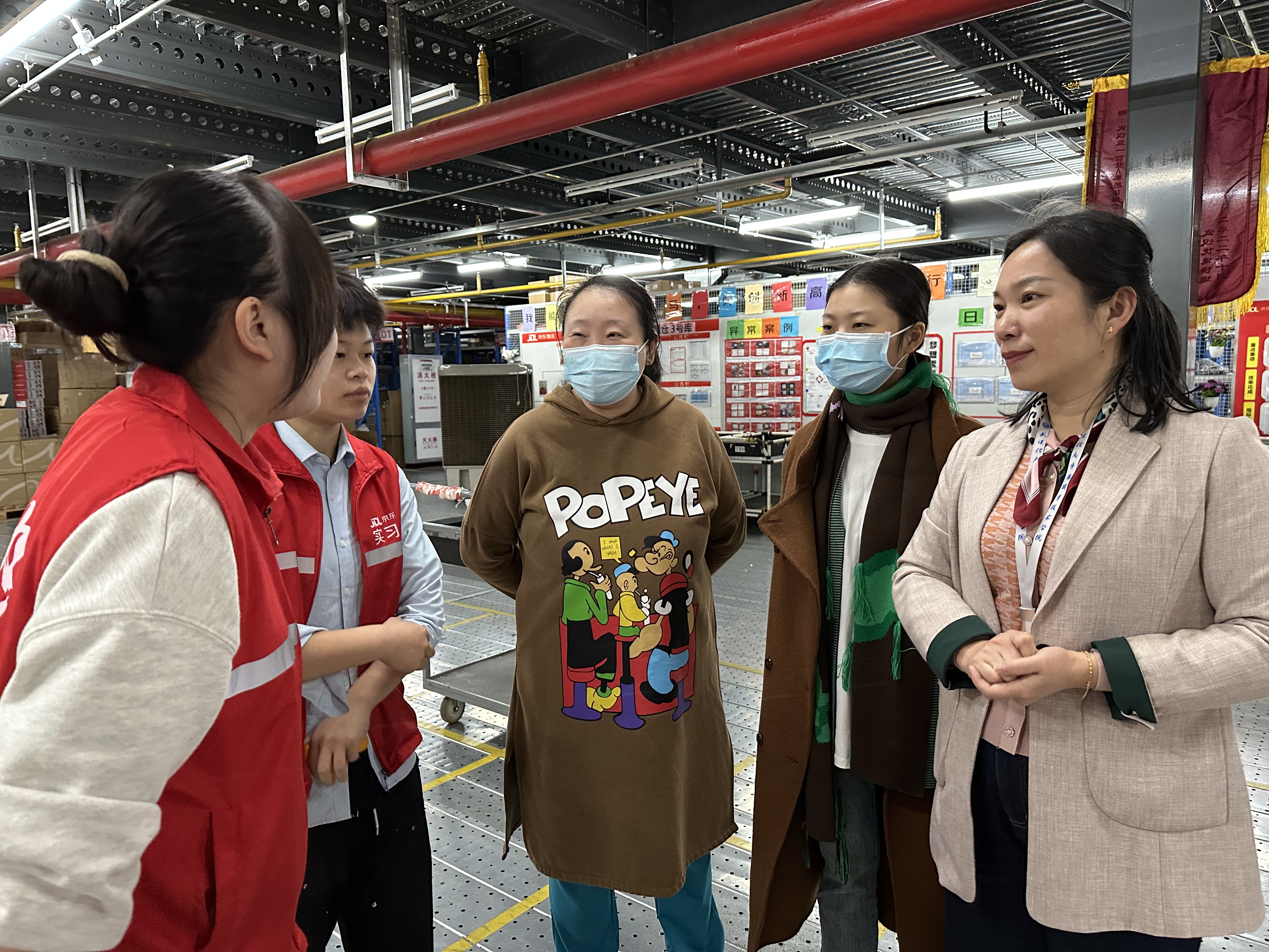 圖4-2 商學(xué)院院長(zhǎng)李靜榮、副院長(zhǎng)陳萍在倉(cāng)里指導(dǎo)學(xué)生，與學(xué)生親切交流